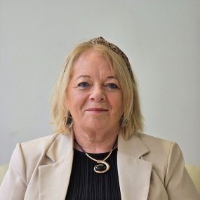 Smiling woman with blonde hair wearing a blazer.