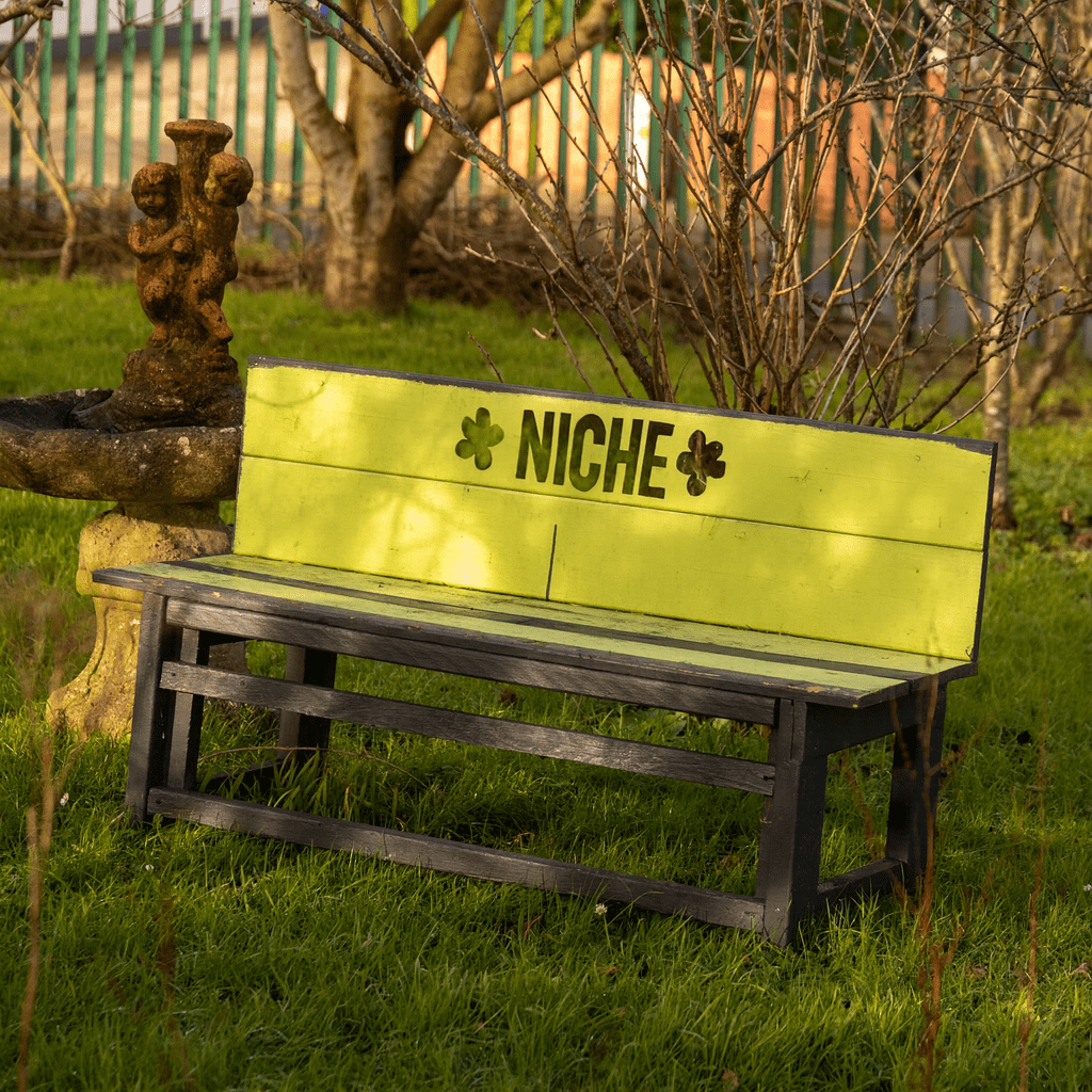 Green bench with "NICHE" written on the back.